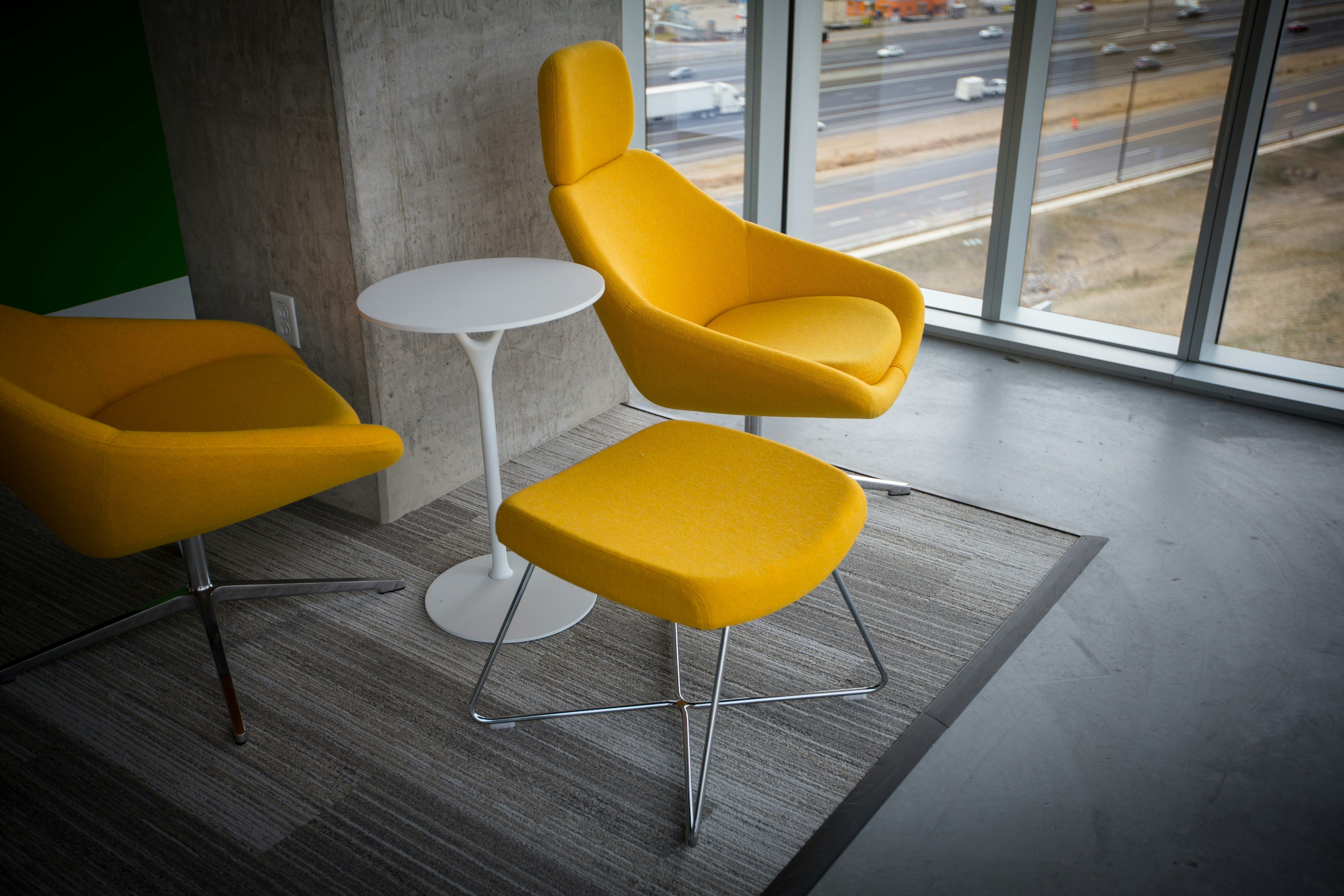 room with yellow fabric chairs and ottoman with table